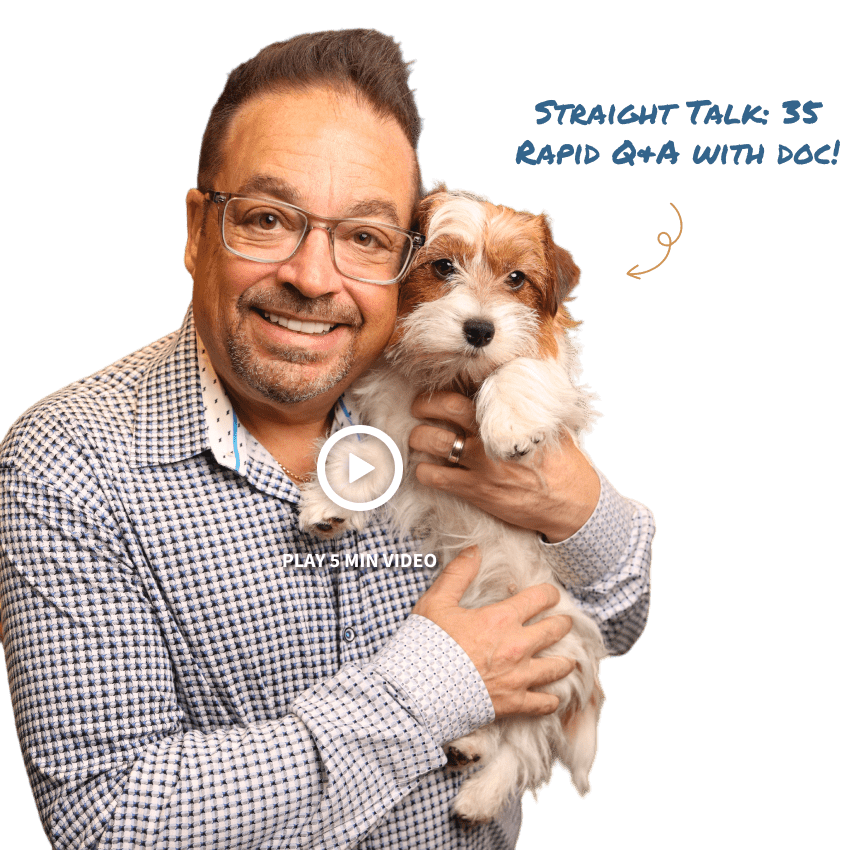Dr. Ron Sherman holding a small dog and warmly smiling