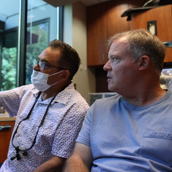 Dr. Ron Sherman with a patient in the dental office explaining the benefits of restorative treatment